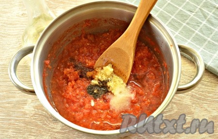 Масса в кастрюле уменьшится в объёме. Добавляем в неё красный и чёрный молотые перцы, пропущенный через пресс чеснок и соль, вливаем растительное масло и уксус, перемешиваем.