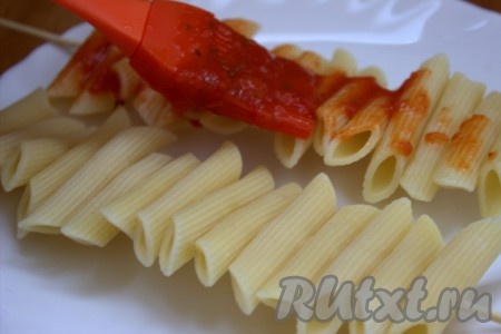 Нанизывать макароны на деревянную шпажку, как на фото. У меня получилось по 15 макаронных перьев на одной шпажке. Поверхность макарон с помощью силиконовой кисточки смазать томатным соусом (или просто кетчупом).