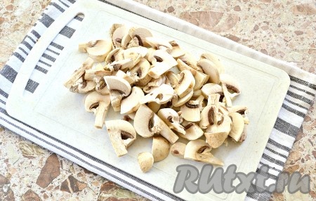 Подготовленные шампиньоны нарезаем тонкими пластинками вместе с ножками. Когда вода с картошкой закипят, выкладываем шампиньоны, после закипания убавляем огонь. Варим картофель и шампиньоны на небольшом огне до полуготовности картошки (минут 10-12).