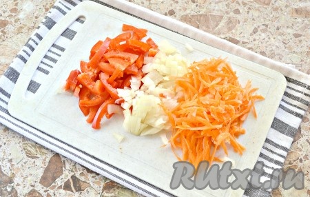 Тем временем натираем морковь. Лук нарезаем на мелкие кубики, а болгарский перец - небольшими кусочками.