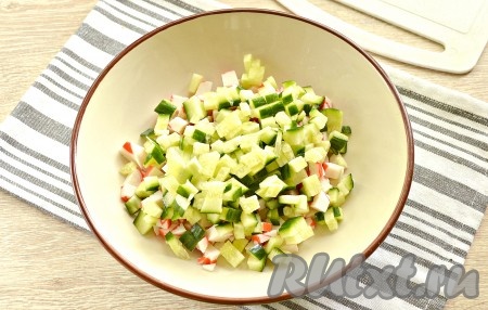 Огурец (очищать от кожуры я его не стала) тоже нарезаем на мелкие кубики, выкладываем в миску с крабовым мясом.