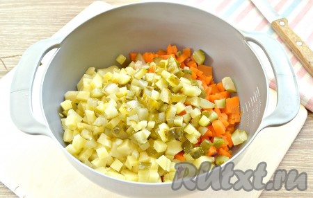 Добавляем в состав оливье маринованные огурцы, тоже нарезанные на мелкие кубики.