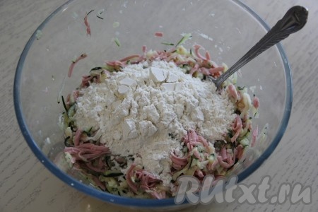 Всыпать муку, перемешать тесто для кабачкового пирога.