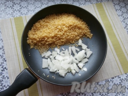 Булгур подвинуть на одну половину сковороды. На другую половину сковороды влить 1 столовую ложку растительного масла и выложить достаточно тонко нарезанный лук.