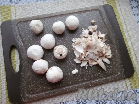 Шляпки шампиньонов очистить ножом, если ножки слишком длинные - отрезать часть.
