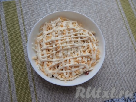 Далее идёт слой натёртых на тёрке варёных яиц, нанести на них сеточку из майонеза, немного подсолить.