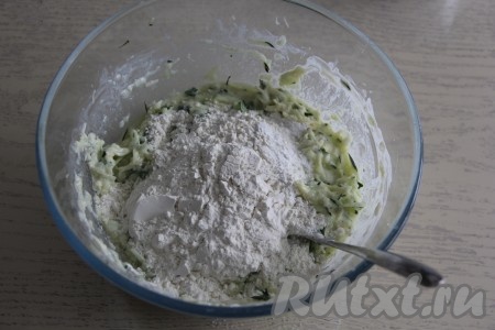 Перемешать кабачково-сырную массу столовой ложкой (или лопаткой), в несколько приёмов всыпать муку и разрыхлитель, каждый раз очень хорошо перемешивая. 