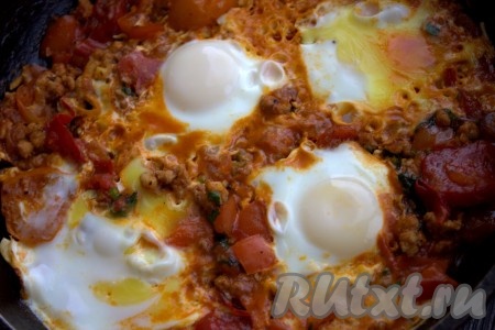 Уменьшить огонь до минимума, накрыть сковороду крышкой и готовить шакшуку 3-5 минут (белок должен схватиться, а желток останется жидким).