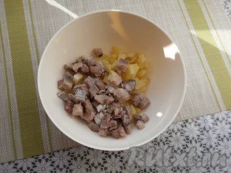 Картофель предварительно отварить в кипящей воде в течение минут 30-35 (до готовности), остудить, очистить, нарезать средними кубиками, выложить в достаточно глубокую миску. К картошке выложить филе селёдки, нарезанное кусочками (или кубиками).