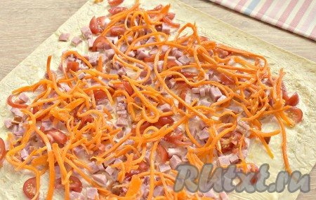 На ветчину и помидоры выкладываем морковку по-корейски, предварительно слегка отжав её от лишнего маринада.
