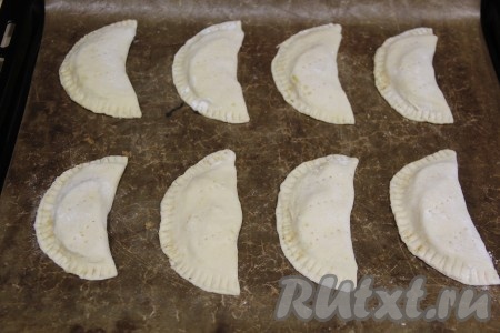 Выложить кокроки с яблоками на противень, застеленный пергаментом (или тефлоновым ковриком). С помощью вилки сделать несколько проколов на поверхности каждого пирожка.