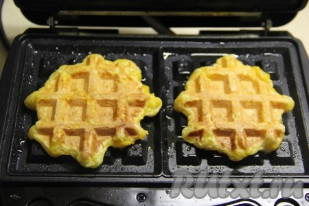 Электровафельницу хорошо разогреть, с помощью кулинарной кисти смазать панели вафельницы растительным маслом. На каждую панель выложить по 1,5 столовых ложки тыквенного теста, крышку вафельницы закрыть. Выпекать вафли до золотистого цвета, а затем переложить их на тарелку. Постепенно испечь все тыквенные вафли из оставшегося теста. Смазывать панели электровафельницы маслом нужно перед каждым выкладыванием теста. Из данного количества ингредиентов получается 12 вафель.