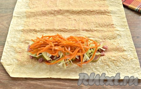 На капустный слой раскладываем половину морковки по-корейски, предварительно отжатой от маринада.