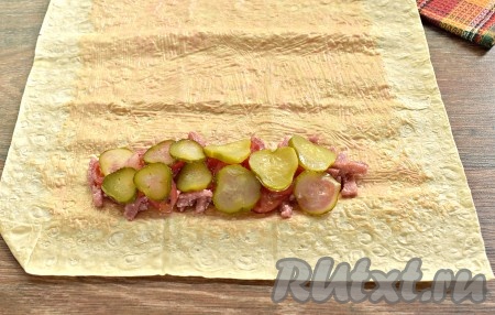 Огурчик нарезаем на достаточно тонкие кружочки. Поверх слоя помидоров выкладываем половину нарезанных огурцов.