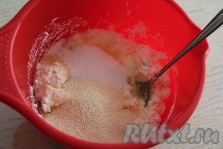В получившуюся творожно-яичную массу всыпать сахар и 4 столовых ложки манки, хорошо перемешать.