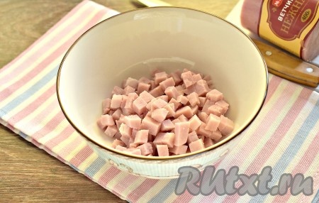 Ветчину нарезаем на небольшие кубики и перекладываем в салатник.