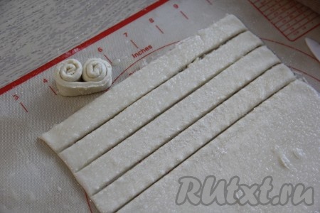 Нарезать тесто на полоски шириной, примерно, 1,5-2 сантиметра. Скрутить полосочки с двух сторон в виде завитушек.