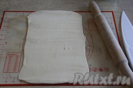 На столе, немного присыпанном мукой, слегка раскатать тесто скалкой.