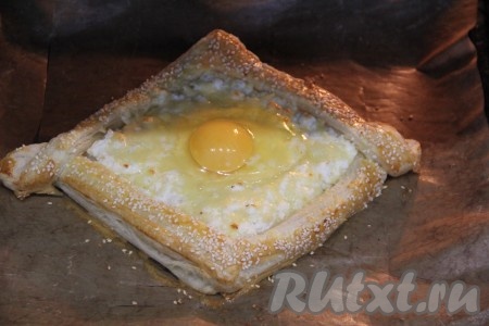 Открыть духовку и выложить яйцо поверх начинки. Оставить ещё хачапури в духовке на 10 минут. 