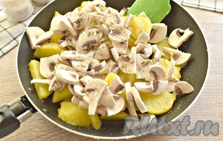 К картошке, обжаренной до слегка румяной корочки, выкладываем нарезанные шампиньоны, солим, перчим, перемешиваем.