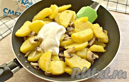 Затем к картошке с шампиньонам выкладываем сметану, перемешиваем.