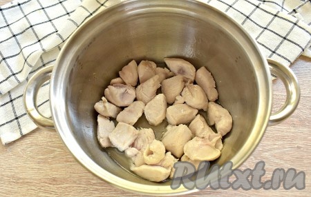 Морковь, чеснок и лук очищаем. Куриное филе нарезаем на кубики среднего размера. В кастрюлю с толстым дном (или в глубокую сковороду, или в казан) вливаем растительное масло, выкладываем кусочки курочки и обжариваем их, периодически перемешивая, на среднем огне минут 5-7 (до появления слегка золотистой корочки).