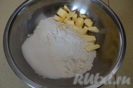 Прежде всего замесим песочное тесто, для этого в достаточно объёмную миску нужно насыпать пшеничную муку, сахар, разрыхлитель, добавить холодное сливочное масло, нарезанное на небольшие кусочки.