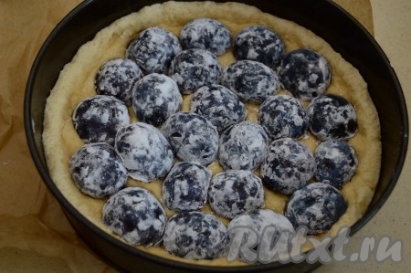 По прошествии времени достать форму с песочной основой из духовки. За это время основа пирога не должна быть готовой, песочное тесто немного "схватится", образовав на поверхности корочку. Выложить внутрь основы сливы срезом вниз. В этот раз я выложила сливы в один слой, но пробовала выкладывать и в 2 слоя - тоже получится вкусно.