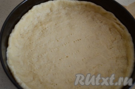 Форму для выпечки (я выпекала в форме диаметром 25 см) застелить пергаментом и смазать стенки растительным маслом. Выложить в форму песочное тесто и равномерно распределить его по дну формы, сформировав небольшой бортик. Если у вас форма будет меньшего диаметра, то бортик делайте более высоким. Наколоть тесто вилкой и отправить форму в духовку, разогретую до 180 градусов. Выпекать песочную основу для пирога 7-10 минут.