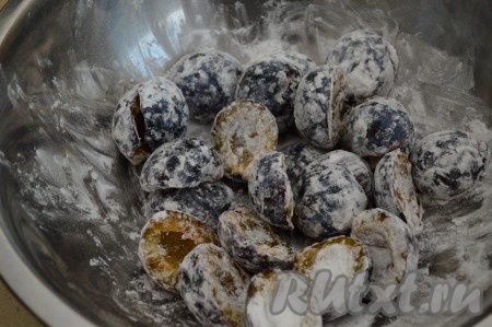 Пока форма с песочной основой в духовке, можно заняться сливовой начинкой нашего пирога. Сливы промыть, разрезать на половинки, косточки удалить. Выложить сливы в миску и присыпать крахмалом, перемешать. Крахмал нужен для того, чтобы сочные сливы своим соком сильно не пропитывали тесто. Если сливы не сочные, крахмал можно не добавлять. Я пробовала готовить этот пирог и с крахмалом, и без него. Если готовить без крахмала, пирог получается более влажным, так как сливовый сок хорошо пропитывает песочную основу.