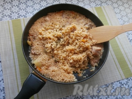 Затем добавить в сковороду булгур, влить горячую воду, добавить лавровый лист, сушёную зелень, подсолить по вкусу, накрыть сковороду крышкой, а после закипания готовить блюдо на минимальном огне, не открывая крышку, 20-25 минут.