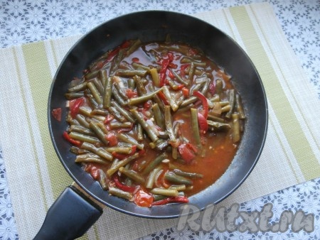 Получившуюся однородную смесь крахмала и воды влить тонкой струйкой, постоянно помешивая, в сковороду со стручковой фасолью и овощами, прогреть на умеренном огне несколько минут (до небольшого загустения томатного соуса).