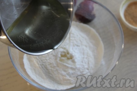 Горячую смесь масла и воды влить в миску с мукой, солью и разрыхлителем, перемешивая песочное тесто вначале ложкой, а затем продолжать замешивать руками. 