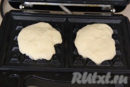 Электровафельницу хорошо разогреть, затем смазать её панели небольшим количеством растительного масла. Выкладывать на каждую панель вафельницы по 1 столовой ложке теста (то есть для выпечки 1 вафли нужно выкладывать 1 столовую ложку теста) и сразу крышку закрыть.