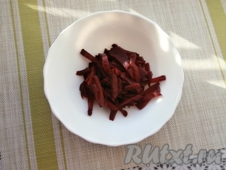 Свеклу вымыть и отварить в кожуре в кипящей воде в течение 50-60 минут (или запечь в разогретой духовке при температуре 180 градусов в течение 1-1,5 часов). Готовая отваренная (или запечённая) свекла должна легко прокалываться вилкой. Свеклу остудить, очистить от кожуры, нарезать брусочками и выложить в тарелку.