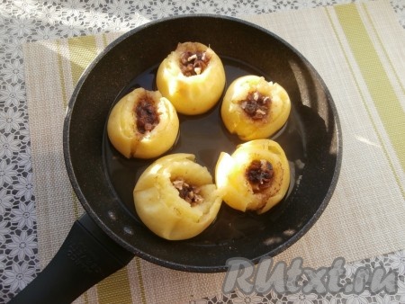 Поместить сковороду на огонь, довести воду до кипения, огонь сделать минимальным. Запекать яблоки под крышкой от 10 до 20 минут (до мягкости яблок). Продолжительность приготовления во многом зависит от сорта яблок. Готовность можно проверить, проткнув яблоки вилкой или ножом.