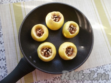 Изюм предварительно промыть. Орехи измельчить, но не очень мелко. Наполнить яблоки изюмом и орехами.