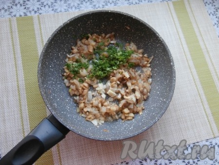 Обжаривать грибы и лук, помешивая, до испарения жидкости (2-3 минуты), затем добавить мелко нарезанную петрушку и измельчённый чеснок. Перемешать, прожарить 1-2 минуты, выключить огонь и немного остудить.