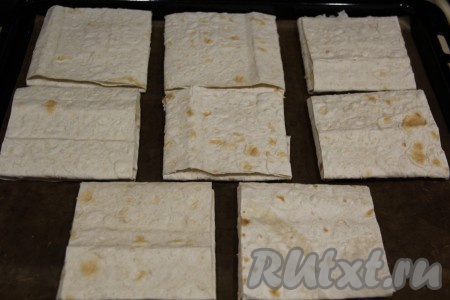 Выложить 8 конвертиков из лаваша с начинкой из творога и сыра на противень, застеленный пергаментом (или силиконовым ковриком).