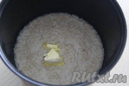 После звукового сигнала (по истечении 15 минут) открыть крышку мультиварки, добавить сливочное масло в овсяную кашу, перемешать.