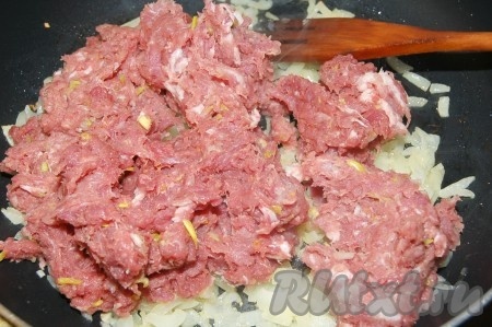 Затем к обжаренному луку добавить свиной фарш.
