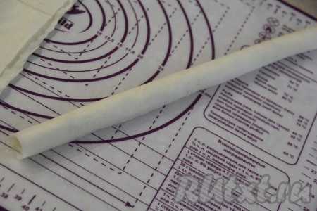 Свернуть лист теста фило, начиная со стороны с начинкой, в плотный рулетик. Аналогично свернуть в плотные рулетики с творожно-сырной начинкой оставшиеся листы теста.