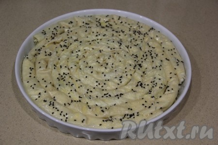 Соединить яичный желток и 1 столовую ложку воды, перемешать. Смазать получившейся желтковой смесью верх пирога из теста фило, присыпать кунжутом. Поставить пирог с творогом и сыром в разогретую до 200 градусов духовку.