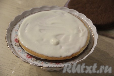 Теперь можно приступать к сборке торта "Мишка на Севере", для этого на плоскую тарелку выложить первый корж (я выложила тёмный корж), промазать его сметанным кремом, выложить корж другого цвета, тоже смазать его кремом. Таким образом, чередуя и промазывая кремом светлые и тёмные коржи, собрать торт. 