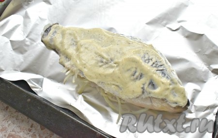 На противень кладём кусок фольги. Помещаем на него карася в майонезе. Сверху распределяем оставшийся соус.