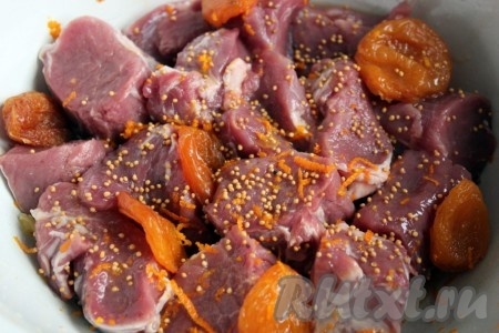 Шкурку от апельсина (оранжевую часть) натереть на тёрке. Полученной апельсиновой цедрой и зерновой горчицей посыпать мясо с курагой, перемешать и оставить мариноваться примерно на 1 час.