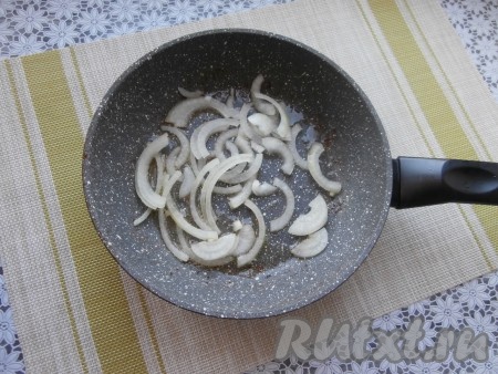 Лук очистить нарезать на достаточно тонки полукольца (или на четвертины). В сковороду влить оставшееся масло, выложить лук, обжарить его 2-3 минуты, иногда перемешивая, на среднем огне.