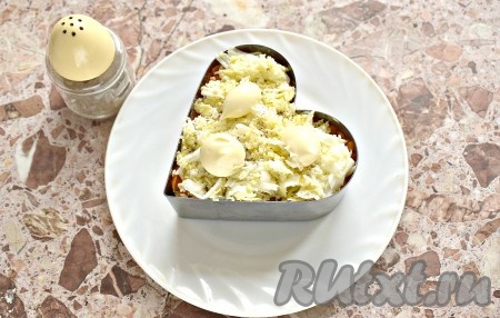 Поверх морковки выкладываем ровным слоем яйца, натёртые на средней тёрке, по вкусу перчим этот слой и покрываем майонезом.