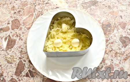 Заранее отварить в кожуре морковку и картошины до готовности (на варку потребуется минут 25-30, готовые корнеплоды будут легко прокалываться вилкой или ножом), остудить овощи и очистить. Яйца отварить с момента закипания воды в течение 8-10 минут, а затем полностью остудить их в холодной воде и очистить. Перья зелёного лука промыть и обсушить. Начинаем собирать салат. Картофель натираем на средней тёрке, выкладываем первым слоем (я выкладывала в формочку, поставив её на плоскую тарелку, на которой блюдо будет подаваться к столу), немного солим и смазываем майонезом.
