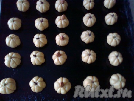 Выкладываем заготовки печенья в форме тыквы на противень, смазанный растительным маслом или застеленный пергаментной бумагой.